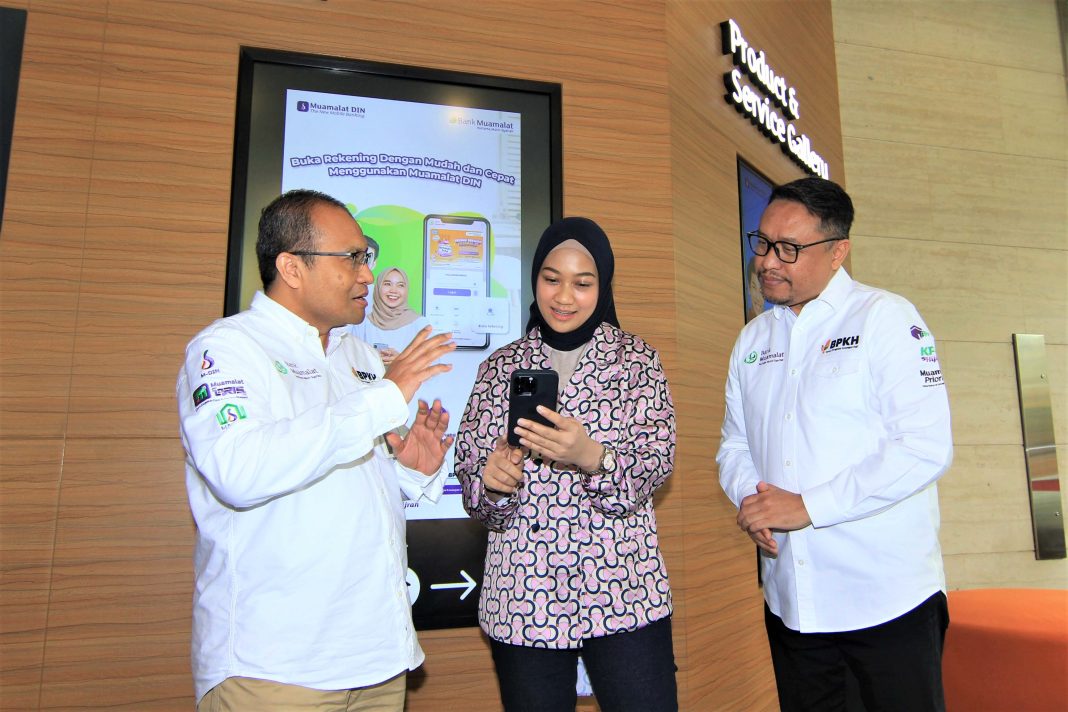 Direktur Operasi PT Bank Muamalat Indonesia Tbk Wahyu Avianto (kiri) menjelaskan pendaftaran haji melalui Muamalat Digital Islamic Network (DIN) kepada nasabah disaksikan oleh Plt Direktur Utama PT Bank Muamalat Indonesia Tbk Hery Syafril (kanan)